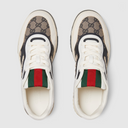 Top view of patterned sneakers with white laces and beige canvas texture