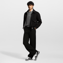 Full-body image of model in casual outfit wearing modern black and white sneakers